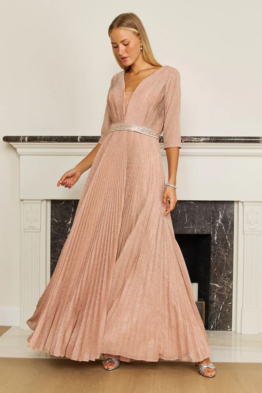 A stunning long sleeve formal evening dress in rose gold, featuring elegant detailing and a flowing silhouette, perfect for a glamorous night out.