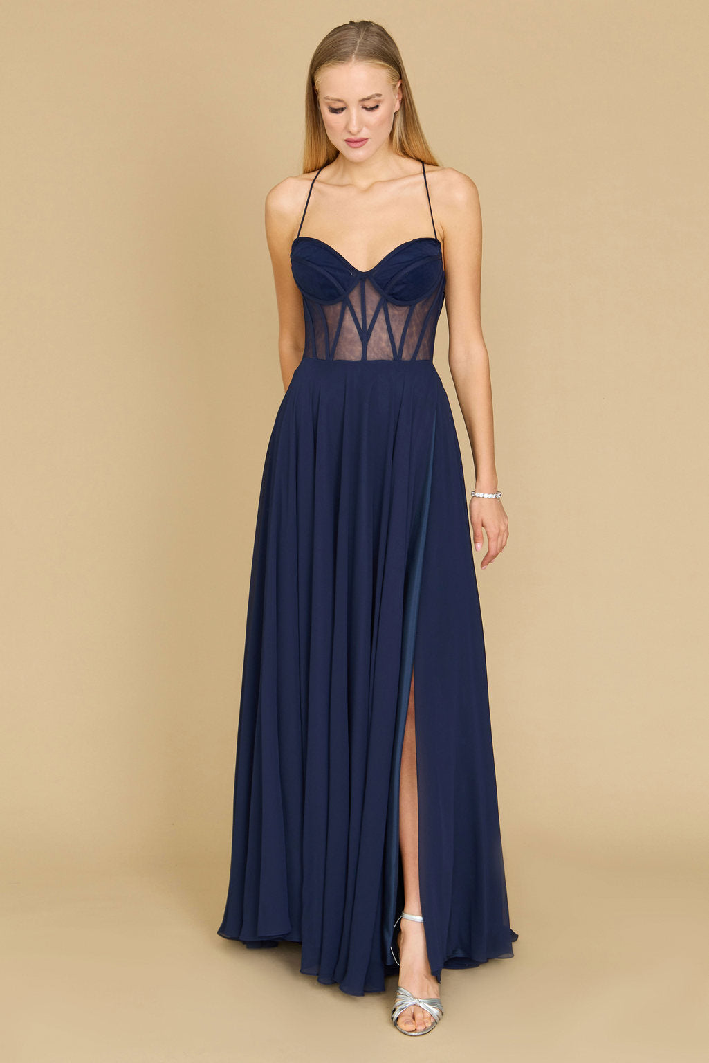 A stunning long chiffon corset formal prom dress in navy, featuring a fitted bodice with intricate detailing and a flowing skirt that cascades elegantly to the floor.