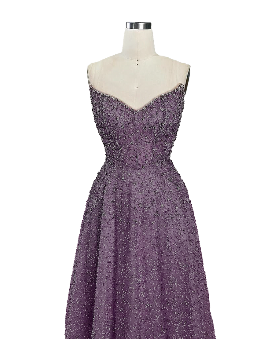 A stunning long strapless formal couture dress adorned with intricate hand-beaded details, showcasing elegance and sophistication.