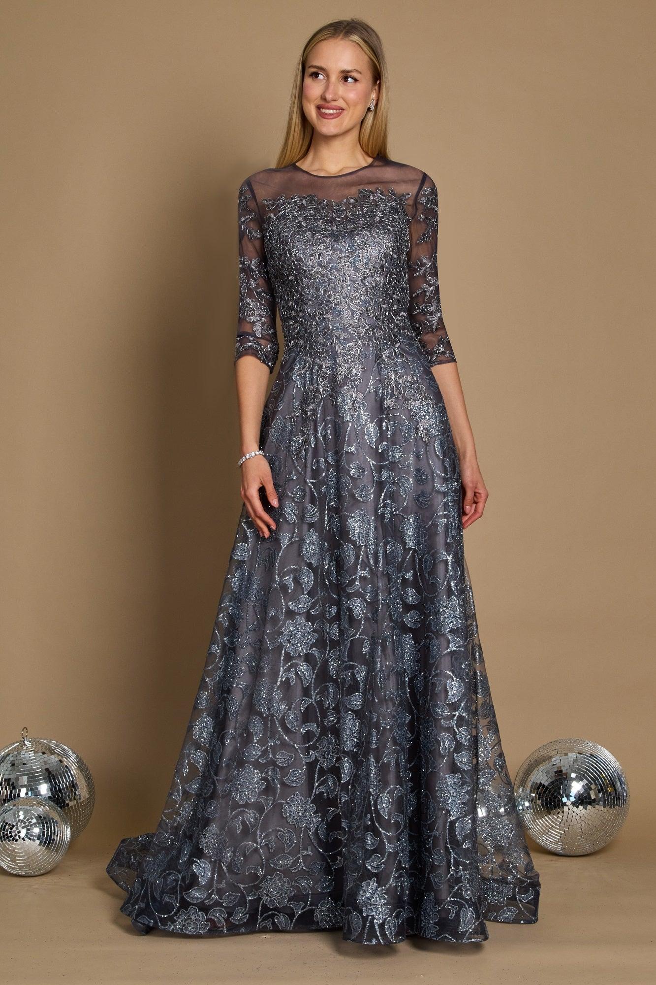 A long formal evening dress in charcoal gray, featuring intricate lace detailing and a flowing silhouette, elegantly draping to the floor.