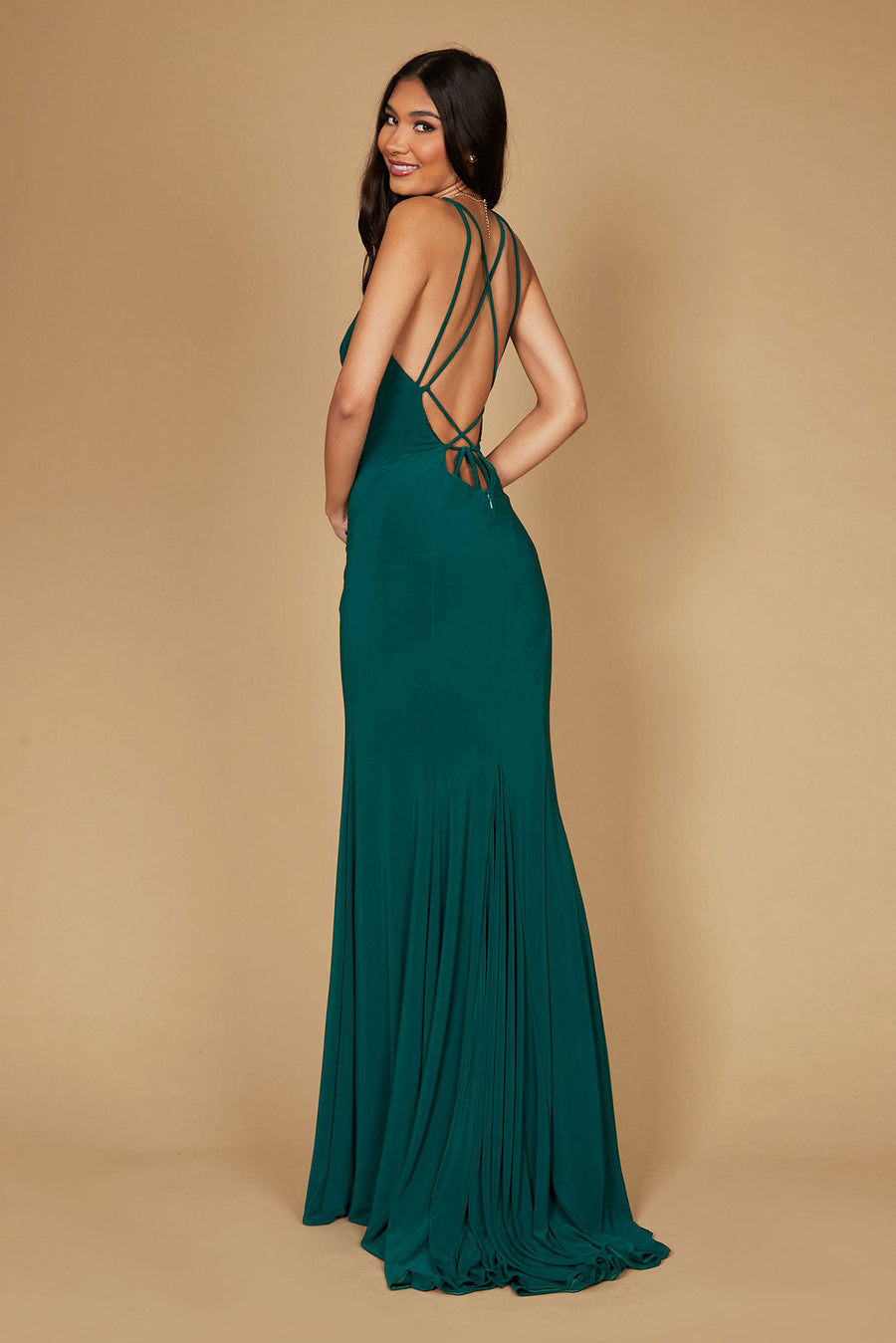 A stunning emerald green long fitted prom dress featuring an open back design, elegantly draping to the floor, perfect for a formal evening event.